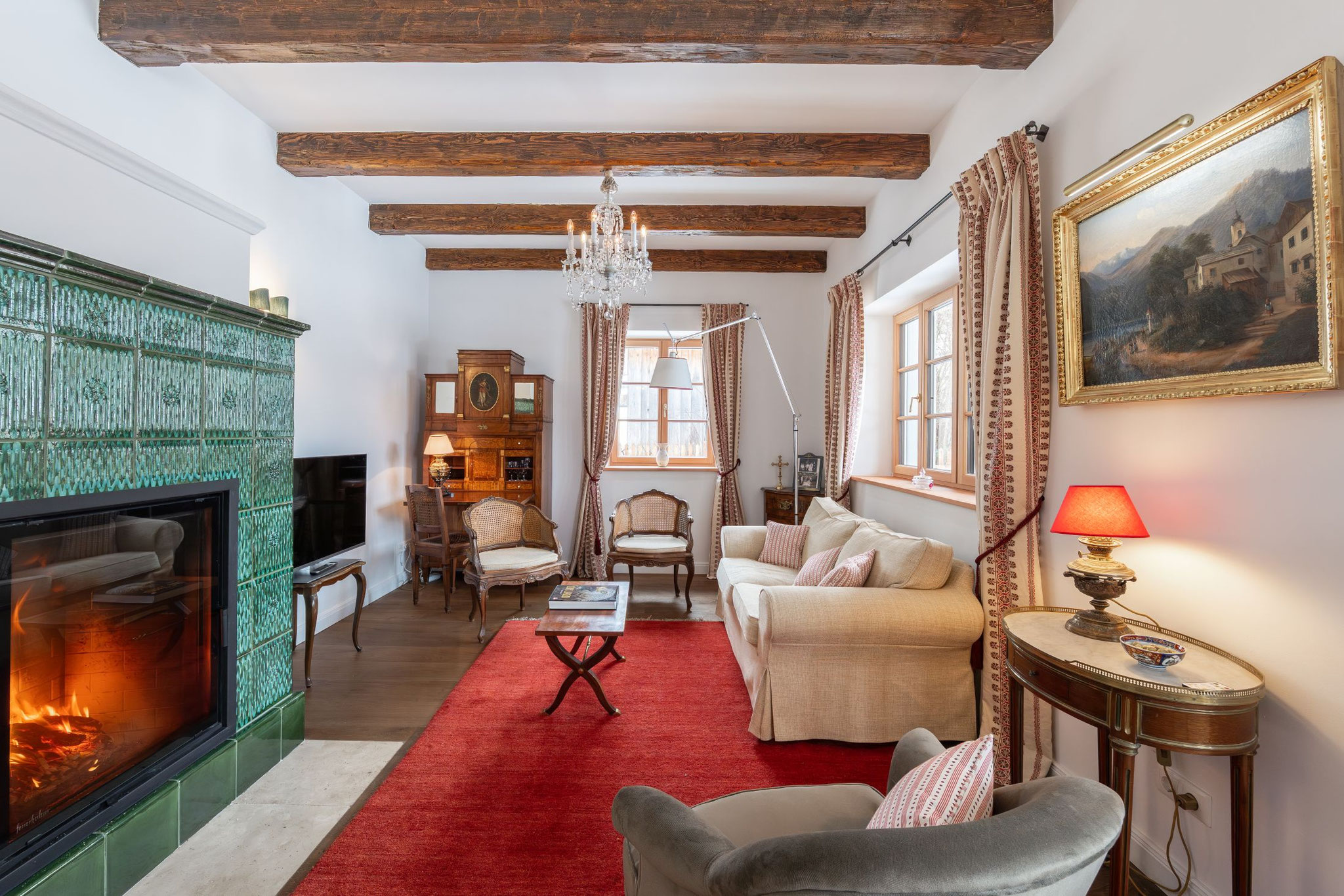 Salon im Erdgeschoss mit grünem Kachelofen, Biedermeier-Möbeln und rotem Teppich